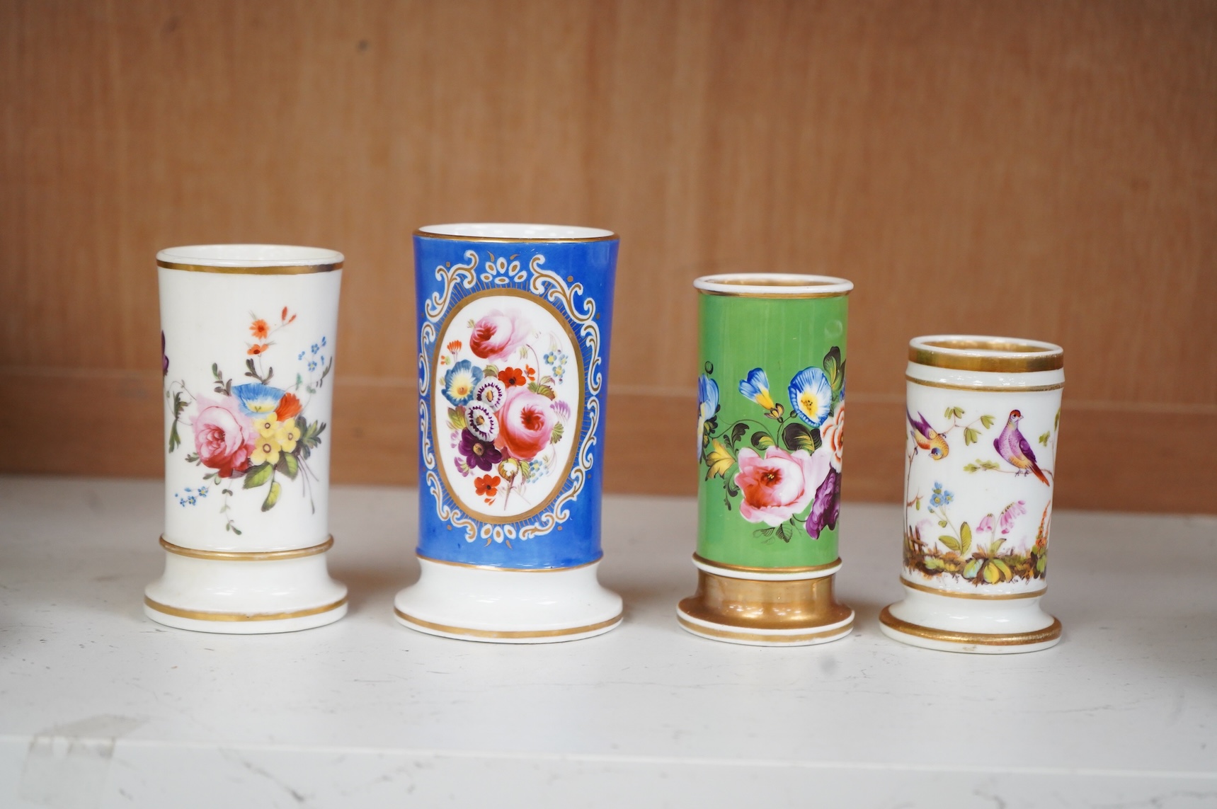 An early 19th century English porcelain miniature pot pourri basket and cover and three spill vases decorated with birds and flowers, largest 11cm high